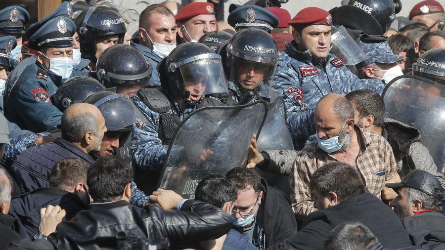 Protesters gather near the parliamentary building during a protest against an agreement to halt fighting over the Nagorno-Karabakh region, in Yerevan, Armenia, Wednesday, Nov. 11, 2020. Thousands of people flooded the streets of Yerevan once again on Wednesday, protesting an agreement between Armenia and Azerbaijan to halt the fighting over Nagorno-Karabakh, which calls for deployment of nearly 2,000 Russian peacekeepers and territorial concessions. Protesters clashed with police, and scores have been detained. (AP Photo/Dmitri Lovetsky)