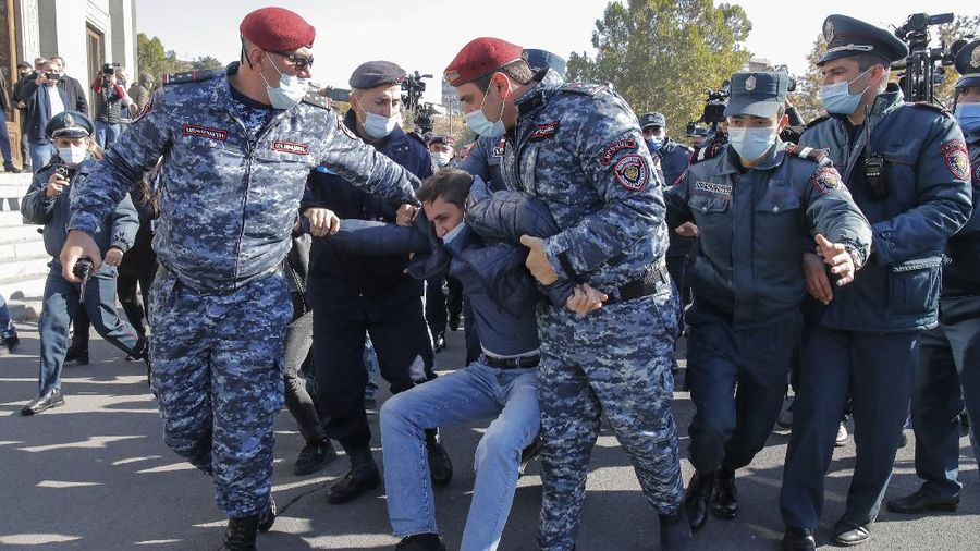 Protesters gather near the parliamentary building during a protest against an agreement to halt fighting over the Nagorno-Karabakh region, in Yerevan, Armenia, Wednesday, Nov. 11, 2020. Thousands of people flooded the streets of Yerevan once again on Wednesday, protesting an agreement between Armenia and Azerbaijan to halt the fighting over Nagorno-Karabakh, which calls for deployment of nearly 2,000 Russian peacekeepers and territorial concessions. Protesters clashed with police, and scores have been detained. (AP Photo/Dmitri Lovetsky)
