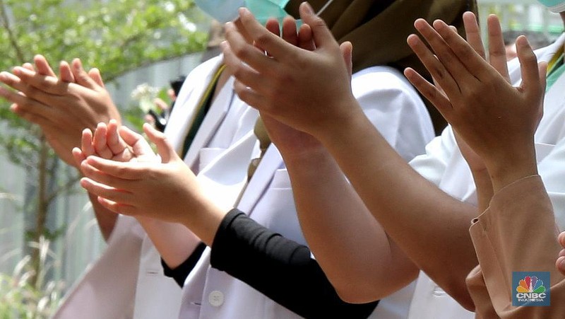 Sejumlah tenaga medis bertepuk tangan di Wisma Atlet Kemayoran, Jakarta, Kamis, 12/11. Tepuk tangan dilakukan untuk mengapresiasi para tenaga kesehatan di Hari Kesehatan Nasional. Hari Kesehatan Nasional yang ke-56 yang biasa diperingati setiap tanggal 12 November. Durasi 56 detik merujuk pada peringatan Hari Kesehatan Nasional (HKN) ke-56.Tepuk tangan itu diikuti oleh sejumlah petugas tenaga medis, Dokter, Perawat, TNI, Relawan Covid-19. Tepuk tangan 56 detik ini diimbau untuk dilakukan serentak pukul 12.00 WIB siang nanti. Kemenkes juga mengimbau momen tepuk tangan 56 menit itu diunggah di media sosial dan dilengkapi sejumlah tagar, di antaranya #gerakan56detik, #HKN56, hingga #terimakasihnakes. Dilihat di Twitter per pukul 08.00 WIB pagi ini, tagar #gerakan56detik telah memuncaki trending topic nasional. (CNBC Indonesia/ Muhammad Sabki)