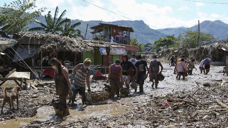 \Warga menyelamatkan barang berharga yang masih bisa digunakan saat terkena banjir akibat terjangan Topan Vamco di Filipina. (AP/Aaron Favila)