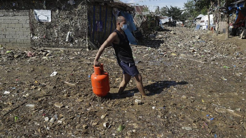 \Warga menyelamatkan barang berharga yang masih bisa digunakan saat terkena banjir akibat terjangan Topan Vamco di Filipina. (AP/Aaron Favila)