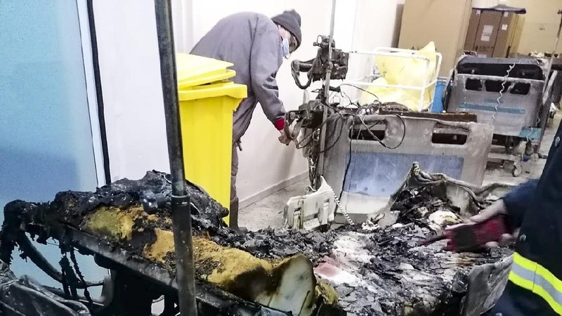 A burned bed from the destroyed COVID-19 intensive care ward at the hospital in Piatra Neamt, northern Romania, Saturday, Nov. 14, 2020, is placed in a corridor after a fire. Romanian officials say a fire at a hospital treating COVID-19 patients has killed 10 people and critically injured seven others as a blaze spread through the intensive care ward designated for people with COVID-19 patients at the public hospital according to the Emergency Situations Inspectorate.(Exploziv TV Neamt via AP)