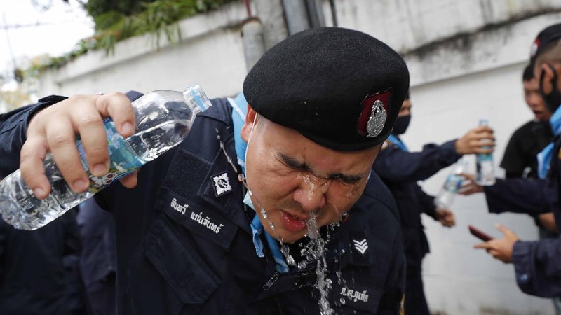 Polisi Thailand menembakan gas air mata kepada para demonstran yang mulai menembus barikade keamanan di depan kantor parlemen Thailand. (AP/Sakchai Lalit)