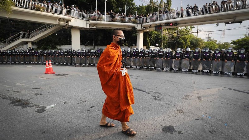 Polisi Thailand menembakan gas air mata kepada para demonstran yang mulai menembus barikade keamanan di depan kantor parlemen Thailand. (AP/Sakchai Lalit)