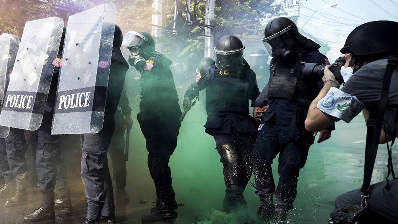Polisi Thailand menembakan gas air mata kepada para demonstran yang mulai menembus barikade keamanan di depan kantor parlemen Thailand. (AP/Sakchai Lalit)
