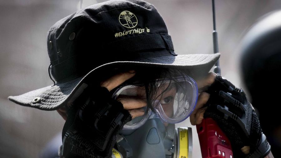 Polisi Thailand menembakan gas air mata kepada para demonstran yang mulai menembus barikade keamanan di depan kantor parlemen Thailand. (AP/Sakchai Lalit)