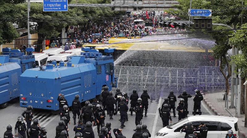Polisi Thailand menembakan gas air mata kepada para demonstran yang mulai menembus barikade keamanan di depan kantor parlemen Thailand. (AP/Sakchai Lalit)