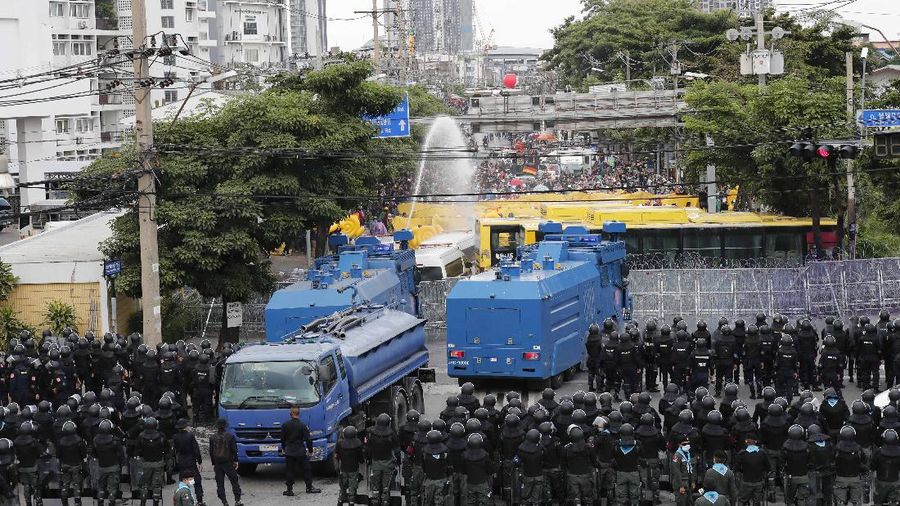 Polisi Thailand menembakan gas air mata kepada para demonstran yang mulai menembus barikade keamanan di depan kantor parlemen Thailand. (AP/Sakchai Lalit)