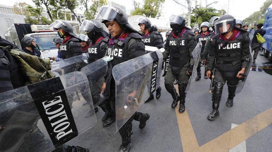 Polisi Thailand menembakan gas air mata kepada para demonstran yang mulai menembus barikade keamanan di depan kantor parlemen Thailand. (AP/Sakchai Lalit)