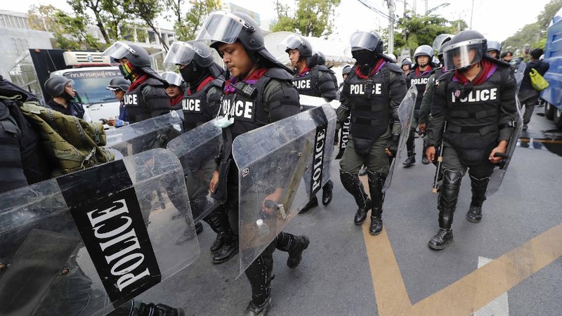 Polisi Thailand menembakan gas air mata kepada para demonstran yang mulai menembus barikade keamanan di depan kantor parlemen Thailand. (AP/Sakchai Lalit)