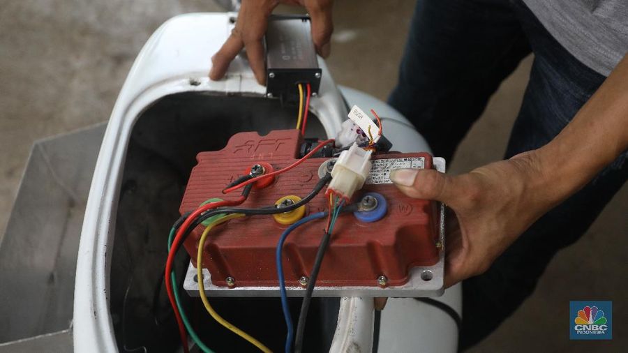 Mekanik memasang baterai motor vespa yang dikonversi menjadi motor listrik di bengkel Petrikbike, Raya Kranggan, Bekasi, Jawa Barat, Rabu (18/11/2020).  (CNBC Indonesia/Andrean Kristianto)