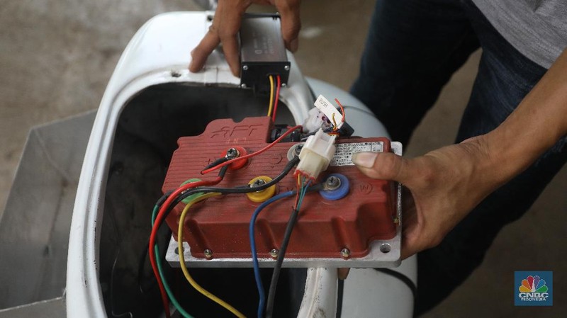 Mekanik memasang baterai motor vespa yang dikonversi menjadi motor listrik di bengkel Petrikbike, Raya Kranggan, Bekasi, Jawa Barat, Rabu (18/11/2020).  (CNBC Indonesia/Andrean Kristianto)