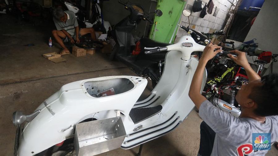 Mekanik memasang baterai motor vespa yang dikonversi menjadi motor listrik di bengkel Petrikbike, Raya Kranggan, Bekasi, Jawa Barat, Rabu (18/11/2020).  (CNBC Indonesia/Andrean Kristianto)
