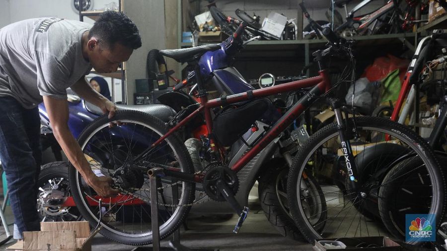 Mekanik memasang baterai motor vespa yang dikonversi menjadi motor listrik di bengkel Petrikbike, Raya Kranggan, Bekasi, Jawa Barat, Rabu (18/11/2020).  (CNBC Indonesia/Andrean Kristianto)