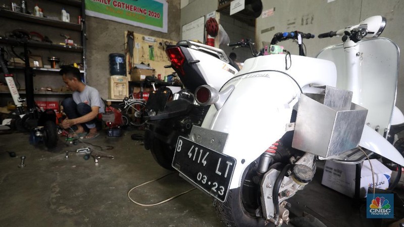Mekanik memasang baterai motor vespa yang dikonversi menjadi motor listrik di bengkel Petrikbike, Raya Kranggan, Bekasi, Jawa Barat, Rabu (18/11/2020).  (CNBC Indonesia/Andrean Kristianto)