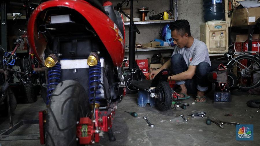 Mekanik memasang baterai motor vespa yang dikonversi menjadi motor listrik di bengkel Petrikbike, Raya Kranggan, Bekasi, Jawa Barat, Rabu (18/11/2020).  (CNBC Indonesia/Andrean Kristianto)