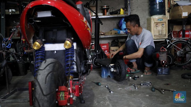 Mekanik memasang baterai motor vespa yang dikonversi menjadi motor listrik di bengkel Petrikbike, Raya Kranggan, Bekasi, Jawa Barat, Rabu (18/11/2020).  (CNBC Indonesia/Andrean Kristianto)