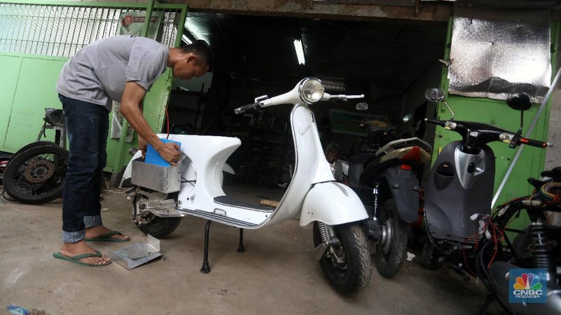 Mekanik memasang baterai motor vespa yang dikonversi menjadi motor listrik di bengkel Petrikbike, Raya Kranggan, Bekasi, Jawa Barat, Rabu (18/11/2020).  (CNBC Indonesia/Andrean Kristianto)