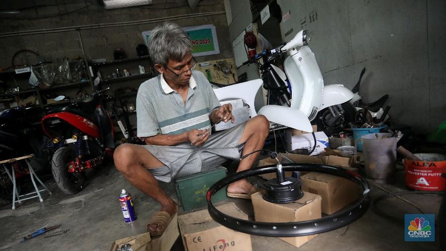 Mekanik memasang baterai motor vespa yang dikonversi menjadi motor listrik di bengkel Petrikbike, Raya Kranggan, Bekasi, Jawa Barat, Rabu (18/11/2020).  (CNBC Indonesia/Andrean Kristianto)