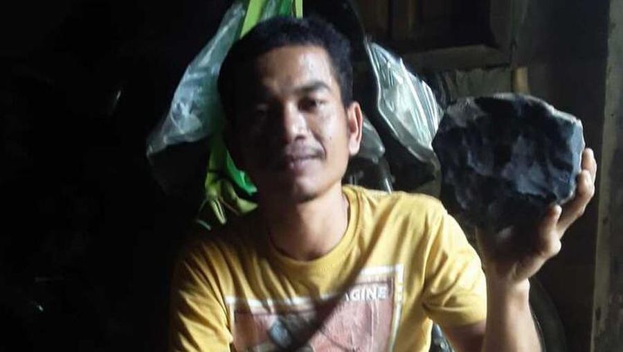 Josua Hutagalung (33) warga Dusun Sitahan Barat, Desa Satahi Nauli, Kecamatan Kolang, Kabupaten Tapanuli Tengah menunjukkan batu yang diduganya sebagai meteor setelah jatuh menimpa rumahnya, Sabtu (1/8/2020).(handout)