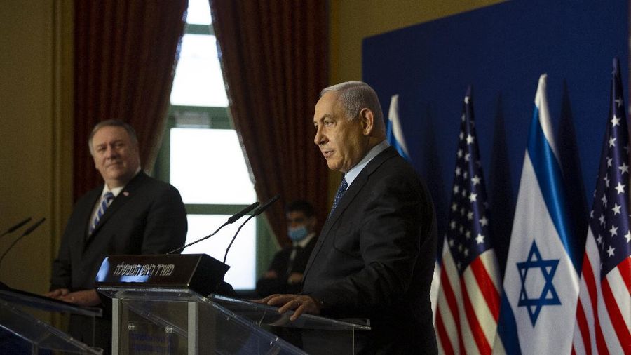 Menteri Luar Negeri AS Mike Pompeo, kiri, mendengarkan Perdana Menteri Israel Benjamin Netanyahu berbicara selama pernyataan bersama mereka setelah pertemuan di Yerusalem, Kamis, (19/11/2020). (AP/Maya Alleruzzo)