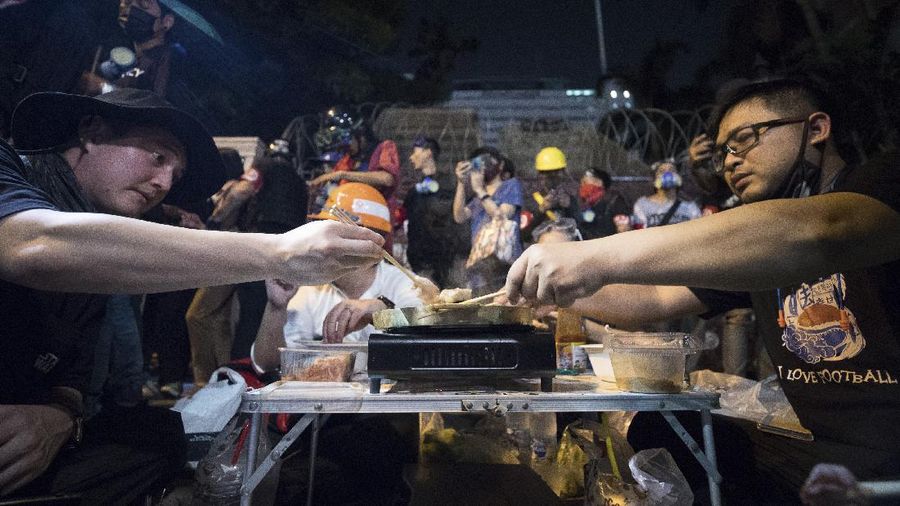 Para pengunjuk rasa membuat hotpot di depan markas polisi saat rapat umum di Bangkok, Thailand. (AP/Wason Wanichakorn)