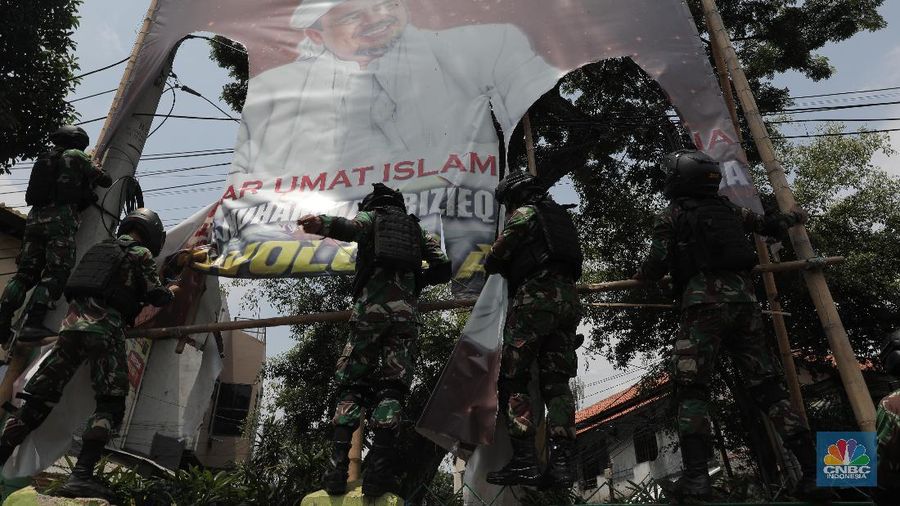 Sejumlah Anggota TNI mencopot baliho bergambar wajah pimpinan Front Pembela Islam (FPI) Habib Rizieq Syihab di Kawasan Tn Abang, Jakarta, Jumat 20/11/2020). (CNBC Indonesia/Muhammad Sabki)