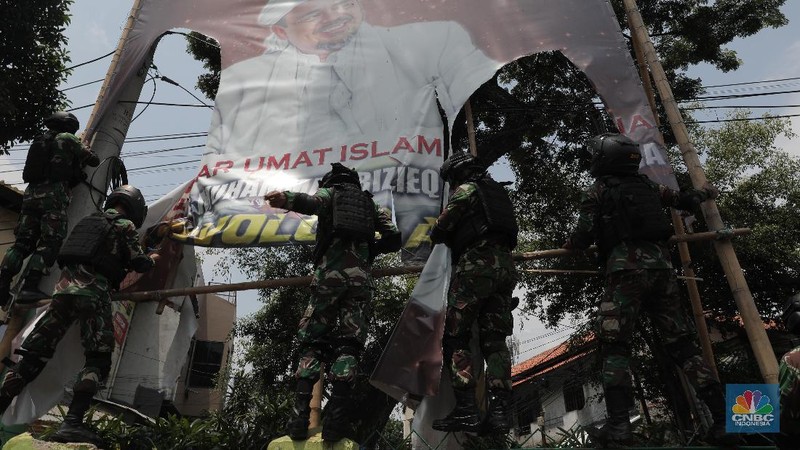 Sejumlah Anggota TNI mencopot baliho bergambar wajah pimpinan Front Pembela Islam (FPI) Habib Rizieq Syihab di Kawasan Tn Abang, Jakarta, Jumat 20/11/2020). (CNBC Indonesia/Muhammad Sabki)