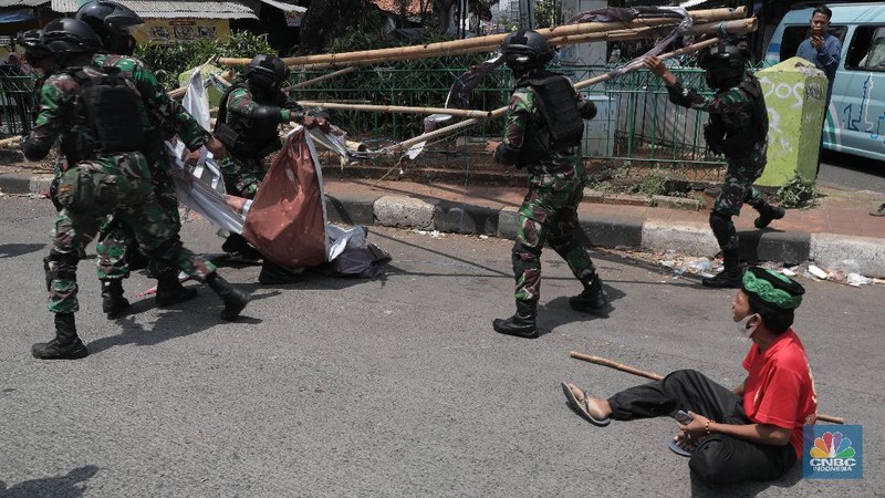 Sejumlah Anggota TNI mencopot baliho bergambar wajah pimpinan Front Pembela Islam (FPI) Habib Rizieq Syihab di Kawasan Tn Abang, Jakarta, Jumat 20/11/2020). (CNBC Indonesia/Muhammad Sabki)