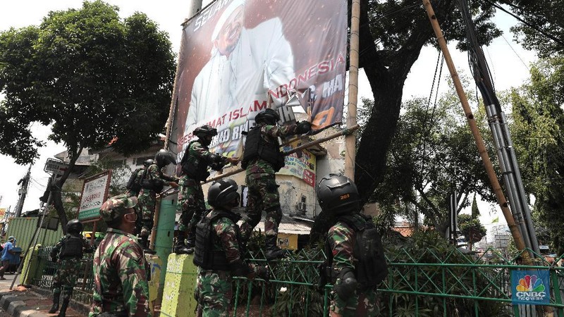 Sejumlah Anggota TNI mencopot baliho bergambar wajah pimpinan Front Pembela Islam (FPI) Habib Rizieq Syihab di Kawasan Tn Abang, Jakarta, Jumat 20/11/2020). (CNBC Indonesia/Muhammad Sabki)