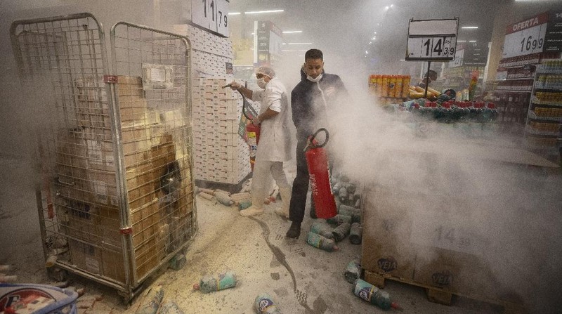 Demonstrators use a crowd control barrier to smash into the entrance of a Carrefour supermarket during a protest against the murder of Black man Joao Alberto Silveira Freitas at a different Carrefour supermarket the night before, on Brazil's National Black Consciousness Day in Rio de Janeiro, Brazil, Friday, Nov. 20, 2020. Freitas died after being beaten by supermarket security guards in the southern Brazilian city of Porto Alegre, sparking outrage as videos of the incident circulated on social media.  (AP Photo/Andre Penner)