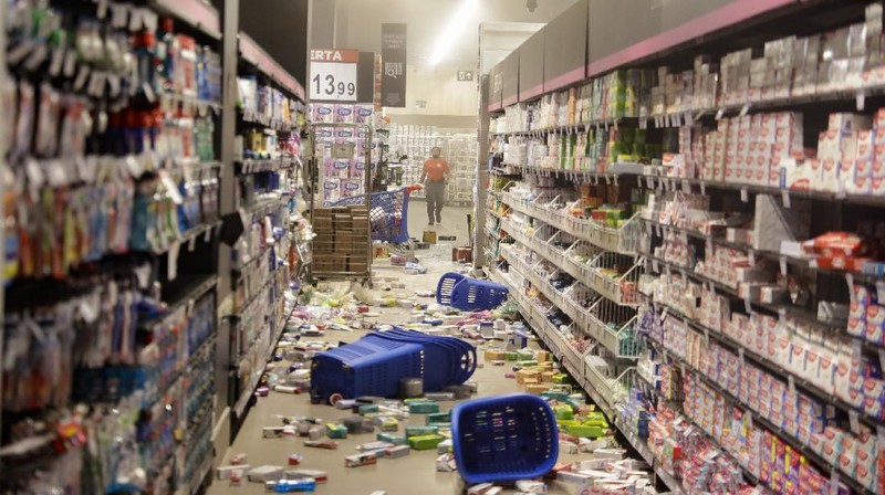 Demonstrators use a crowd control barrier to smash into the entrance of a Carrefour supermarket during a protest against the murder of Black man Joao Alberto Silveira Freitas at a different Carrefour supermarket the night before, on Brazil's National Black Consciousness Day in Rio de Janeiro, Brazil, Friday, Nov. 20, 2020. Freitas died after being beaten by supermarket security guards in the southern Brazilian city of Porto Alegre, sparking outrage as videos of the incident circulated on social media.  (AP Photo/Andre Penner)