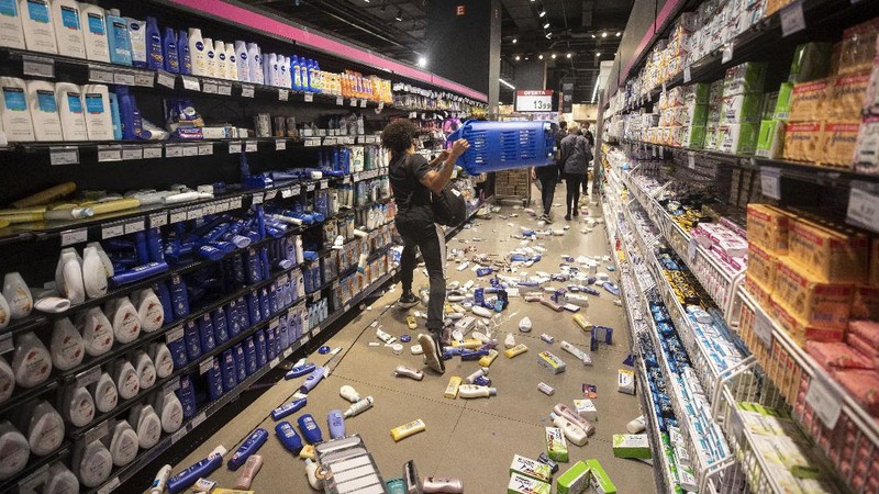 Demonstrators use a crowd control barrier to smash into the entrance of a Carrefour supermarket during a protest against the murder of Black man Joao Alberto Silveira Freitas at a different Carrefour supermarket the night before, on Brazil's National Black Consciousness Day in Rio de Janeiro, Brazil, Friday, Nov. 20, 2020. Freitas died after being beaten by supermarket security guards in the southern Brazilian city of Porto Alegre, sparking outrage as videos of the incident circulated on social media.  (AP Photo/Andre Penner)
