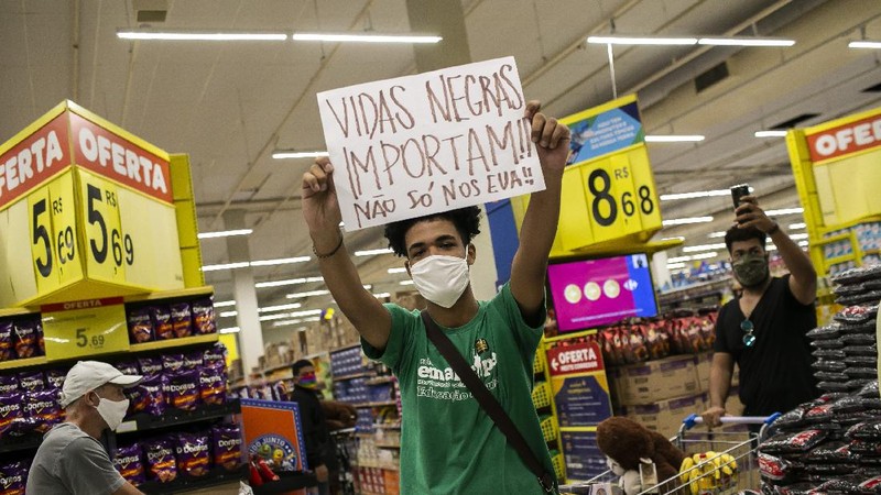 Demonstrators use a crowd control barrier to smash into the entrance of a Carrefour supermarket during a protest against the murder of Black man Joao Alberto Silveira Freitas at a different Carrefour supermarket the night before, on Brazil's National Black Consciousness Day in Rio de Janeiro, Brazil, Friday, Nov. 20, 2020. Freitas died after being beaten by supermarket security guards in the southern Brazilian city of Porto Alegre, sparking outrage as videos of the incident circulated on social media.  (AP Photo/Andre Penner)