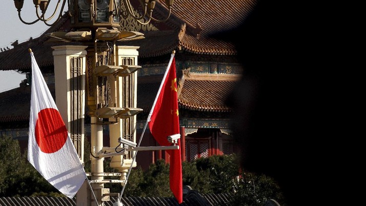 China Japan A Chinese paramilitary policeman is silhouetted as he stands guard near Japanese and Chinese national flags decorated near the Tiananmen Gate in Beijing, Friday, Oct. 26, 2018. Japanese Prime Minister Shinzo Abe held a second meeting with his Chinese counterpart Li Keqiang on Friday during the first formal visit to Beijing by a Japanese leader in nearly seven years that heralds warming ties following years of acrimony. (AP Photo/Andy Wong)