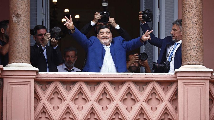FILE - In this Dec. 26, 2019 file photo, former soccer great Diego Maradona flashes victory signs to fans below at the Casa Rosada government house after meeting with Argentine President Alberto Fernandez in Buenos Aires, Argentina. Decades ago, Maradona held up his team's soccer trophy at this spot on the balcony after winning the World Cup in Mexico in 1986. The Argentine soccer great who was among the best players ever and who led his country to the 1986 World Cup title before later struggling with cocaine use and obesity, died from a heart attack on Wednesday, Nov. 25, 2020, at his home in Buenos Aires. He was 60. (AP Photo/Marcos Brindicci, File)