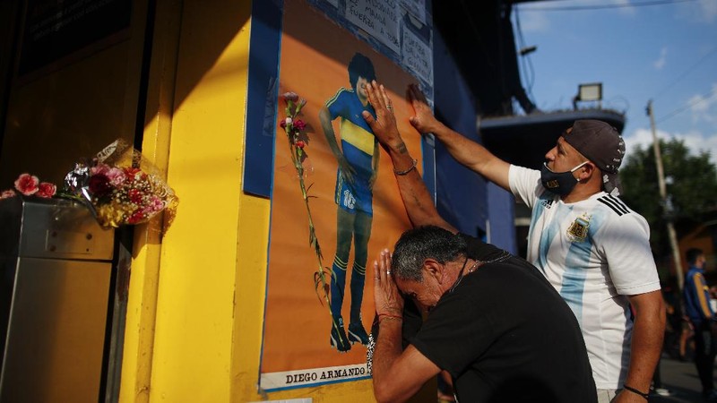 Soccer fans carry a banner of Diego Maradona in downtown Buenos Aires, Argentina, Wednesday, Nov. 25, 2020. Diego Maradona, the Argentine soccer great who was among the best players ever and who led his country to the 1986 World Cup title died from a heart attack at his home in Buenos Aires. He was 60. (AP Photo/Victor Caivano)