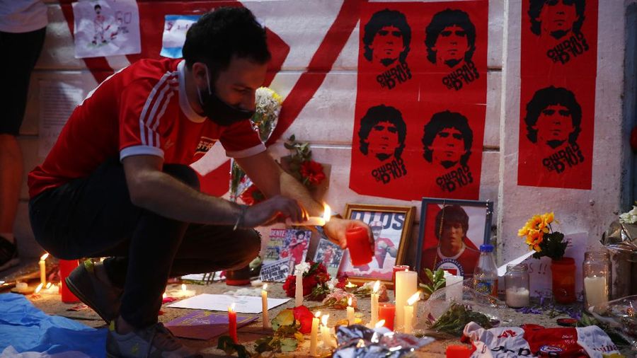 Soccer fans carry a banner of Diego Maradona in downtown Buenos Aires, Argentina, Wednesday, Nov. 25, 2020. Diego Maradona, the Argentine soccer great who was among the best players ever and who led his country to the 1986 World Cup title died from a heart attack at his home in Buenos Aires. He was 60. (AP Photo/Victor Caivano)