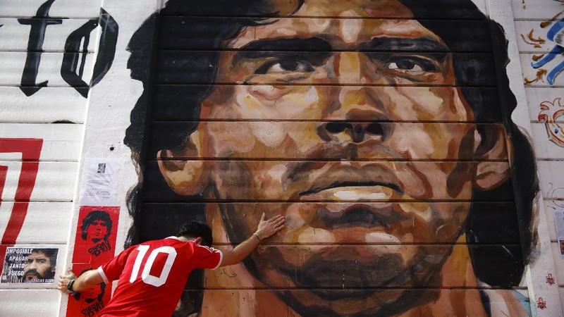 Soccer fans carry a banner of Diego Maradona in downtown Buenos Aires, Argentina, Wednesday, Nov. 25, 2020. Diego Maradona, the Argentine soccer great who was among the best players ever and who led his country to the 1986 World Cup title died from a heart attack at his home in Buenos Aires. He was 60. (AP Photo/Victor Caivano)