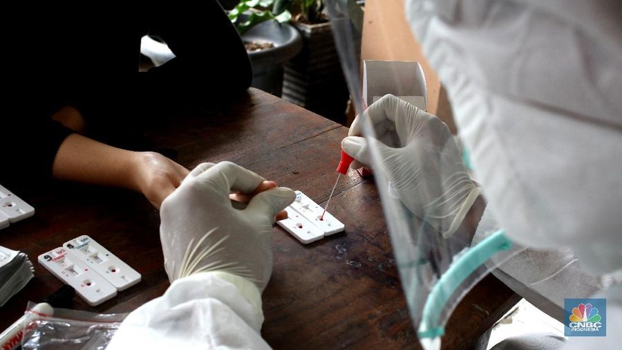 A worker sprays a colleague with disinfectant after a burial of someone who presumably died of the coronavirus at a cemetery in Medan, North Sumatra, Indonesia, Tuesday, Nov. 24, 2020.(AP Photo/Binsar Bakkara)