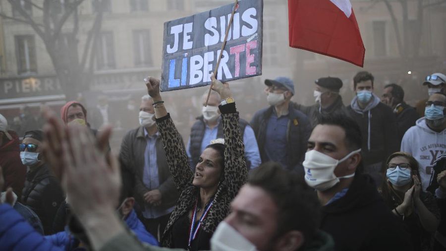 Restaurants and bars owners hold a banner that reads, 'attention angry coffee shop owners', as they stage a protest against the nation wide lockdown in front of a local administration center in Bayonne, southwestern France, Friday, Nov. 27, 2020. France's health minister said Thursday his country is readying to start administering COVID-19 vaccines in late December but warned that people will still have to wear masks and keep their distance even after vaccines are widely available. (AP Photo/Bob Edme)