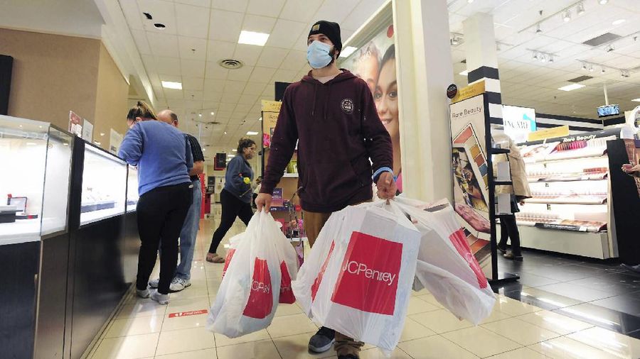 Shoppers wait in line at an electronics store in Calgary, Alberta, Friday, Nov. 27, 2020, amid a worldwide COVID-19 pandemic. (Jeff McIntosh/The Canadian Press via AP)
