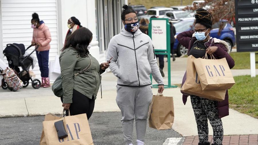 Shoppers wait in line at an electronics store in Calgary, Alberta, Friday, Nov. 27, 2020, amid a worldwide COVID-19 pandemic. (Jeff McIntosh/The Canadian Press via AP)