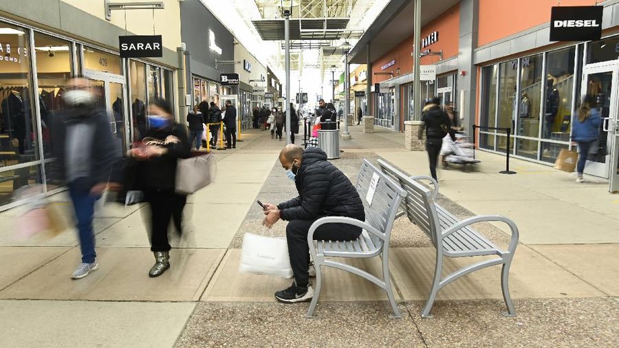 Shoppers wait in line at an electronics store in Calgary, Alberta, Friday, Nov. 27, 2020, amid a worldwide COVID-19 pandemic. (Jeff McIntosh/The Canadian Press via AP)