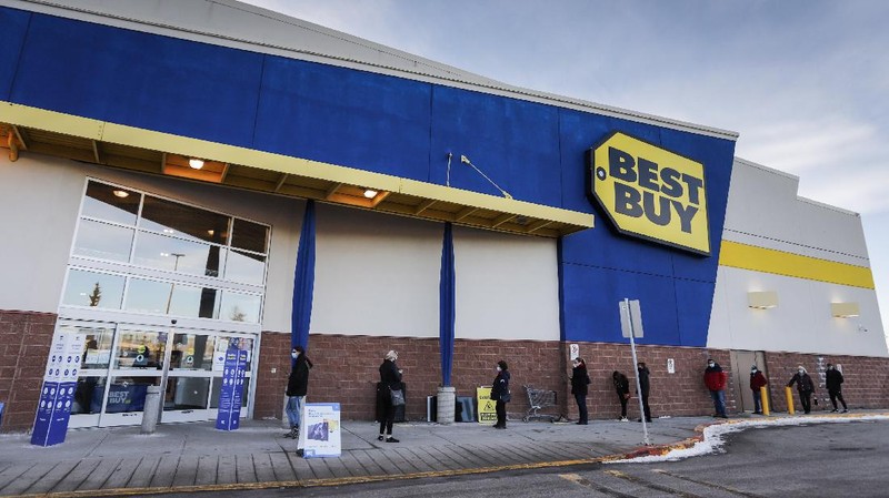 Shoppers wait in line at an electronics store in Calgary, Alberta, Friday, Nov. 27, 2020, amid a worldwide COVID-19 pandemic. (Jeff McIntosh/The Canadian Press via AP)