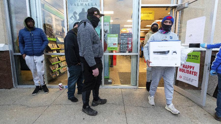 Shoppers wait in line at an electronics store in Calgary, Alberta, Friday, Nov. 27, 2020, amid a worldwide COVID-19 pandemic. (Jeff McIntosh/The Canadian Press via AP)