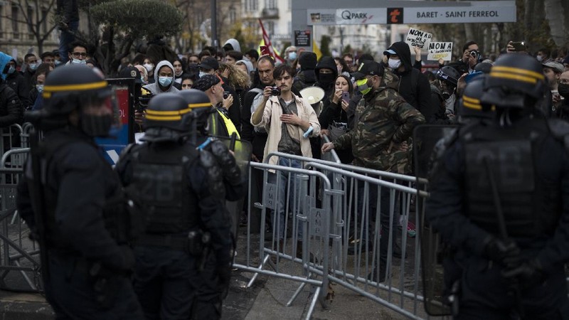 Protesters hold signs during a demonstration against a security law that would restrict sharing images of police, Saturday, Nov. 28, 2020 in Marseille. Civil liberties groups and journalists are concerned that the measure will stymie press freedoms and allow police brutality to go undiscovered and unpunished. The cause has gained fresh impetus in recent days after footage emerged of French police officers beating up a Black man, triggering a nationwide outcry. (AP Photo/Daniel Cole)