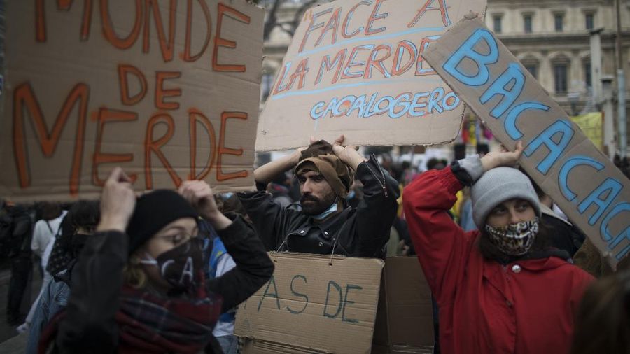 Protesters hold signs during a demonstration against a security law that would restrict sharing images of police, Saturday, Nov. 28, 2020 in Marseille. Civil liberties groups and journalists are concerned that the measure will stymie press freedoms and allow police brutality to go undiscovered and unpunished. The cause has gained fresh impetus in recent days after footage emerged of French police officers beating up a Black man, triggering a nationwide outcry. (AP Photo/Daniel Cole)