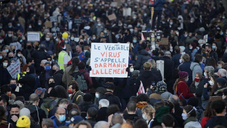 Protesters hold signs during a demonstration against a security law that would restrict sharing images of police, Saturday, Nov. 28, 2020 in Marseille. Civil liberties groups and journalists are concerned that the measure will stymie press freedoms and allow police brutality to go undiscovered and unpunished. The cause has gained fresh impetus in recent days after footage emerged of French police officers beating up a Black man, triggering a nationwide outcry. (AP Photo/Daniel Cole)