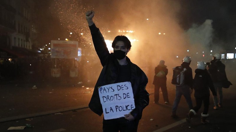 Protesters hold signs during a demonstration against a security law that would restrict sharing images of police, Saturday, Nov. 28, 2020 in Marseille. Civil liberties groups and journalists are concerned that the measure will stymie press freedoms and allow police brutality to go undiscovered and unpunished. The cause has gained fresh impetus in recent days after footage emerged of French police officers beating up a Black man, triggering a nationwide outcry. (AP Photo/Daniel Cole)